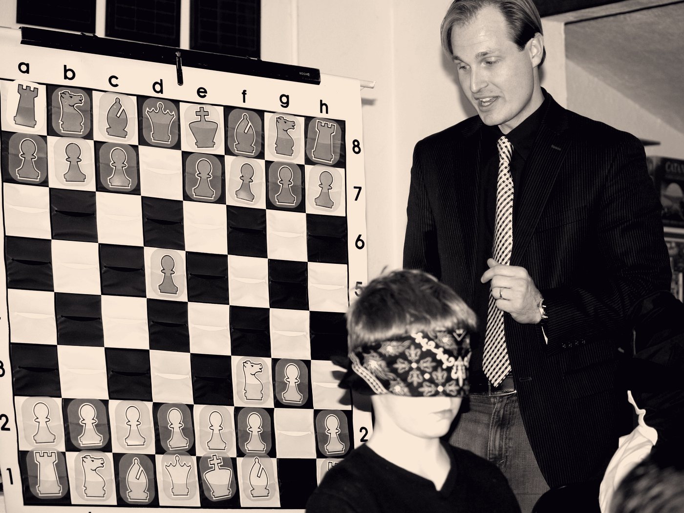 Daniel Vellotti teaching a blindfolded student at a wall-mounted demonstration board.
