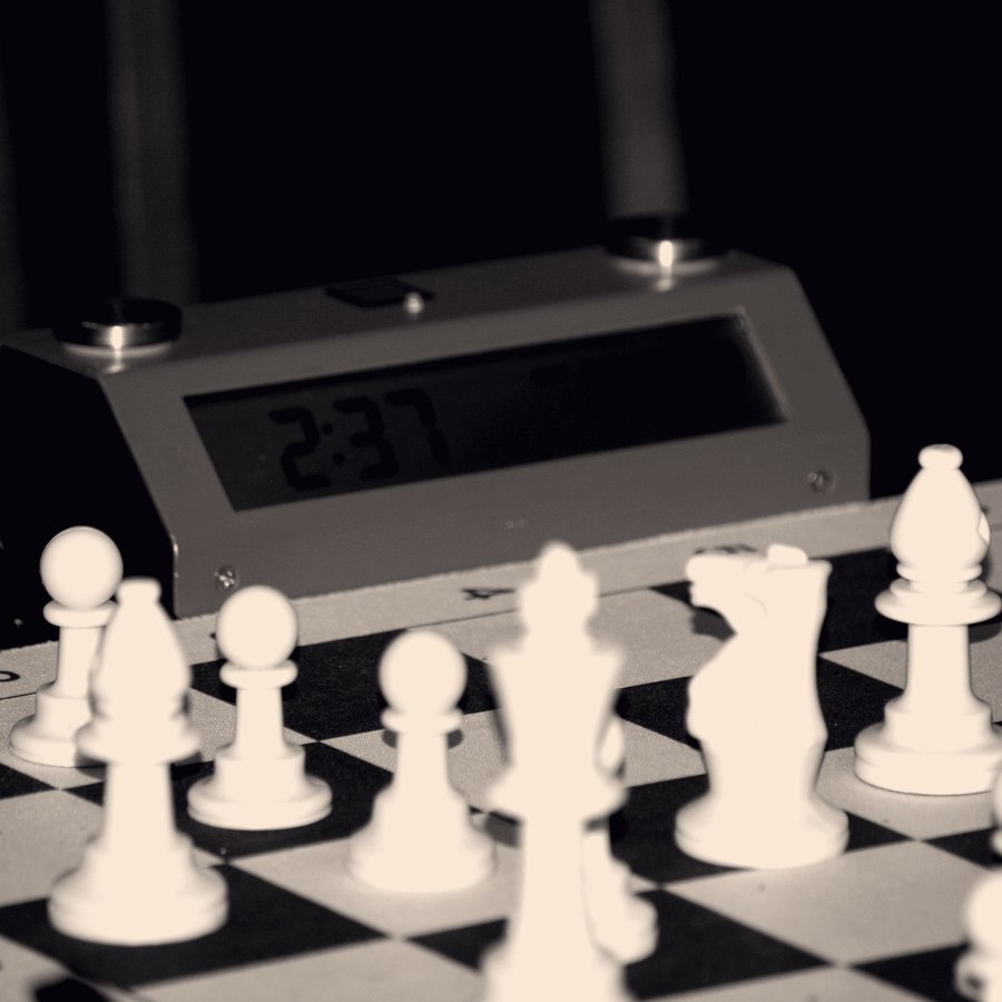 A digital chess clock reading 2:37 behind pieces on a board.